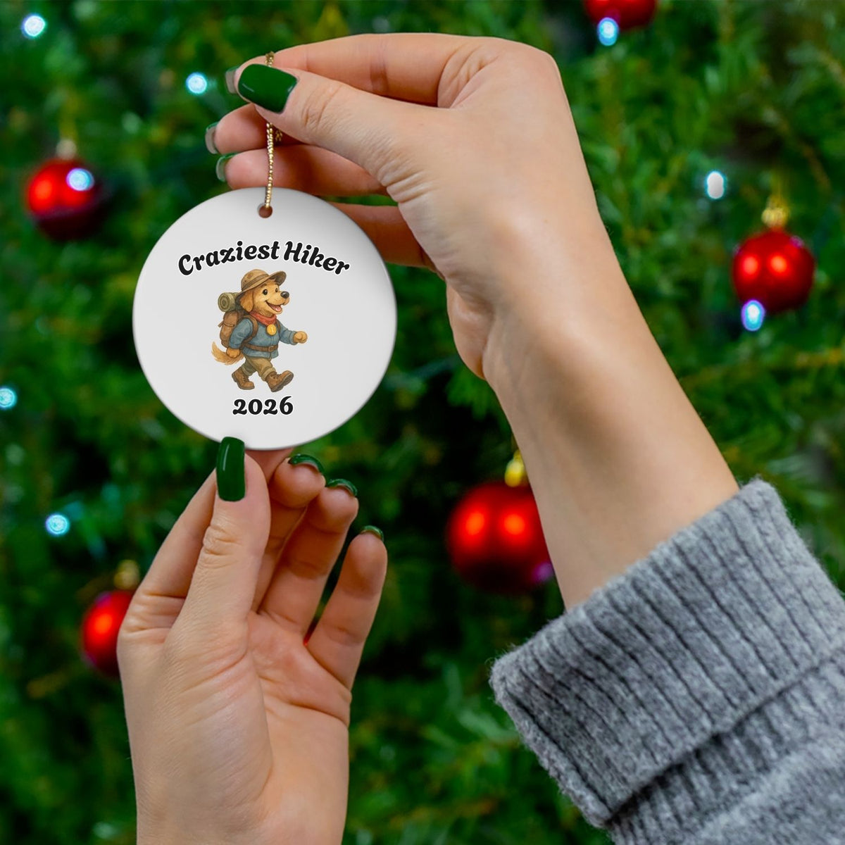Personalized hiking ornament shown in front of Christmas tree, featuring an animal hiker design and custom year.