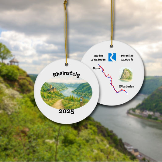 Front and back of the Rheinsteig keepsake ornament with vineyard watercolor scene and stylized trail map. Shown against a scenic Rhine Valley backdrop.